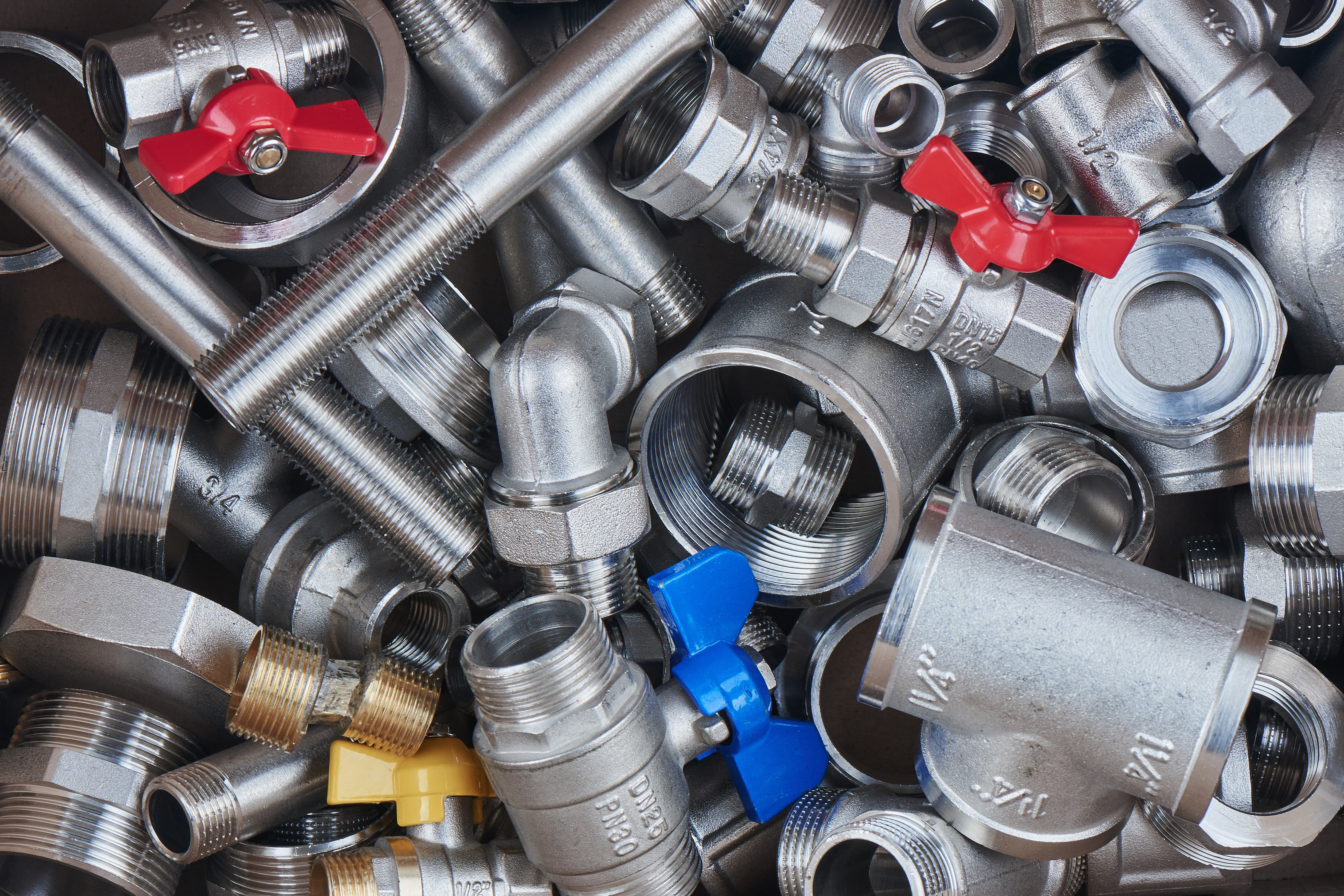 Conjunto de válvulas, conexões e registros metálicos usados em sistemas hidráulicos.